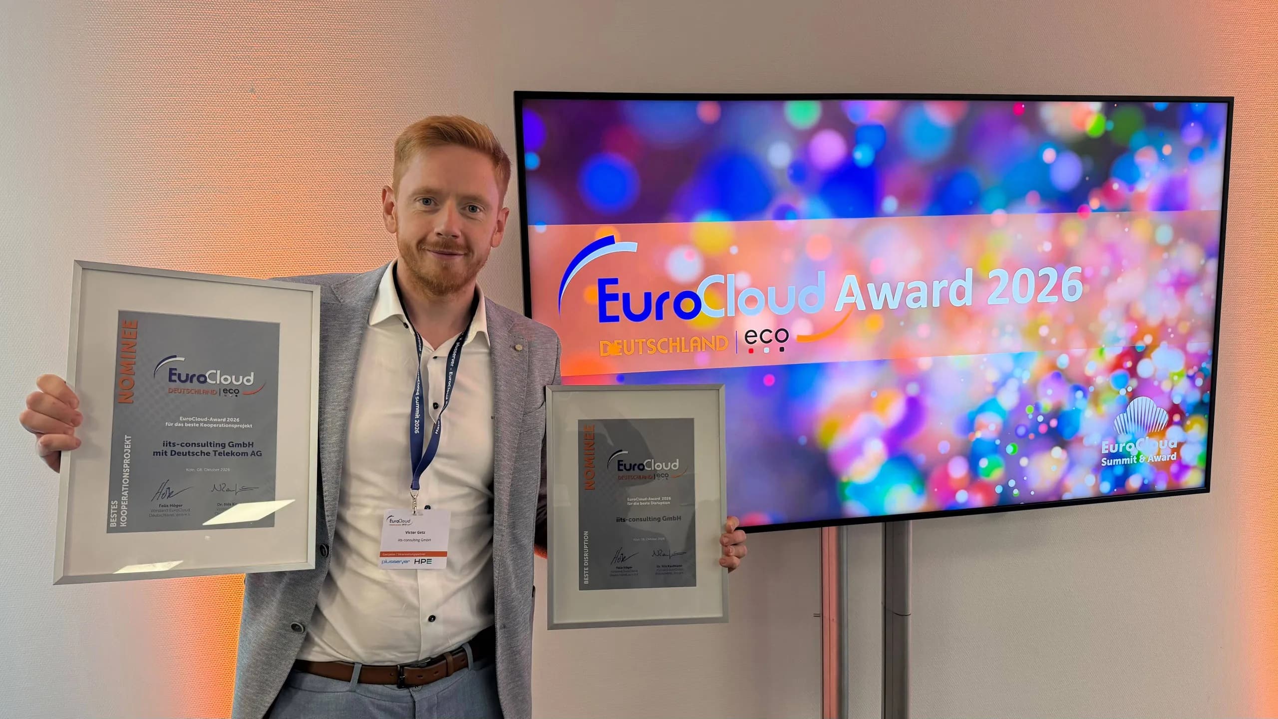 Victor Getz, CTO & Co-Founder of iits-consulting, holding two framed EuroCloud Deutschland certificates.